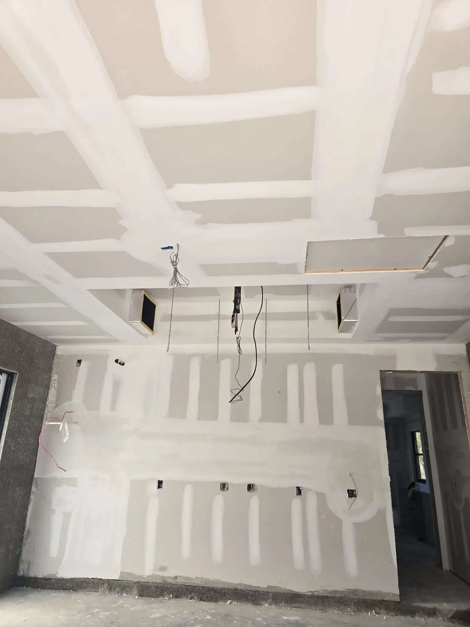 Taped and coated drywall ceiling joints with vents and wiring, drywall finishing in Lehigh Acres
