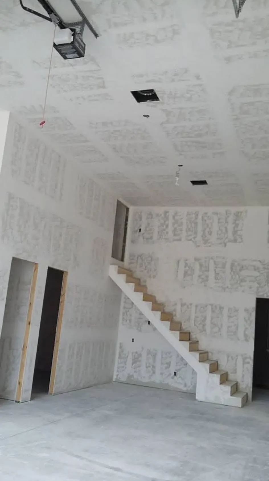 Finished drywall interior with a staircase and doorways